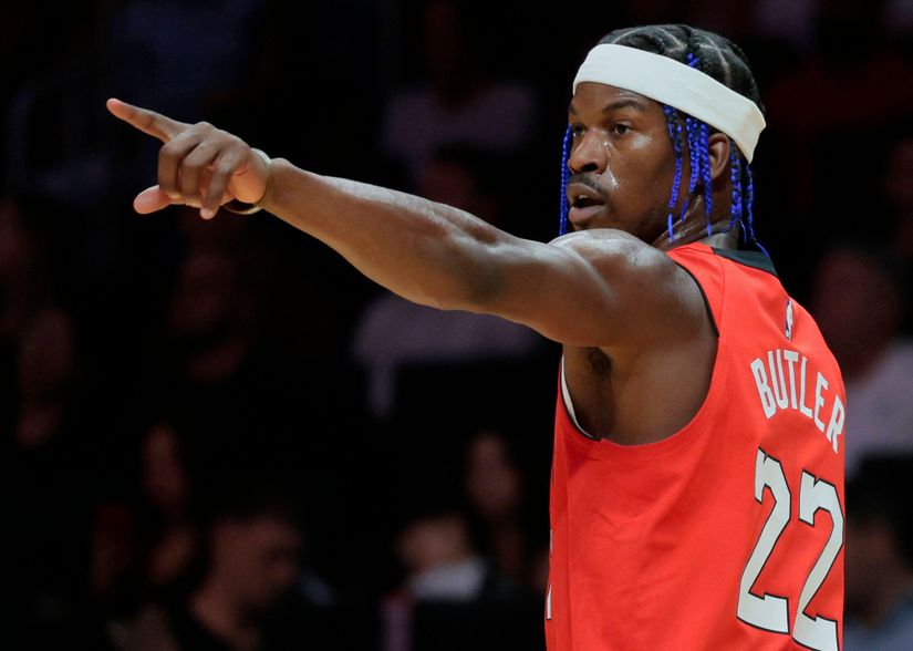 Le basketteur, vêtu d'un maillot rouge numéroté 22 et coiffé d'un bandeau, pointe le bras droit tendu. Sur fond sombre et spectateurs flous, il incarne l'esprit de compétition qui se dégage des moments sportifs palpitants de Betway.