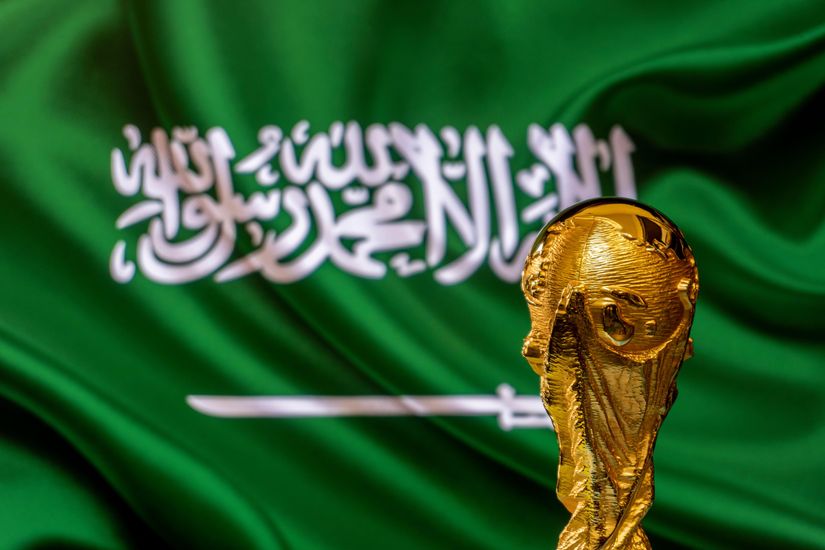 The iconic World Cup trophy stands proudly against the backdrop of the Saudi Arabian flag, symbolizing a nations quest for glory. Explore more with Betway Arabia, where every game is an opportunity to delve into the passion and excitement of world-class football.
