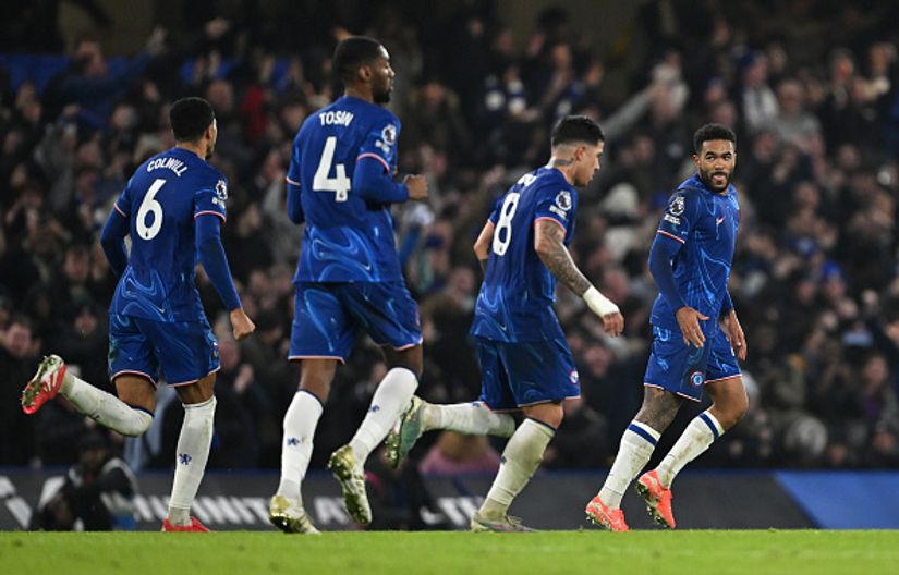 Five soccer players in blue jerseys dominate the field, with a buzzing crowd in the background. The energy is palpable, much like the excitement surrounding Betway Arabia as fans anticipate every move and cheer for their favorites.